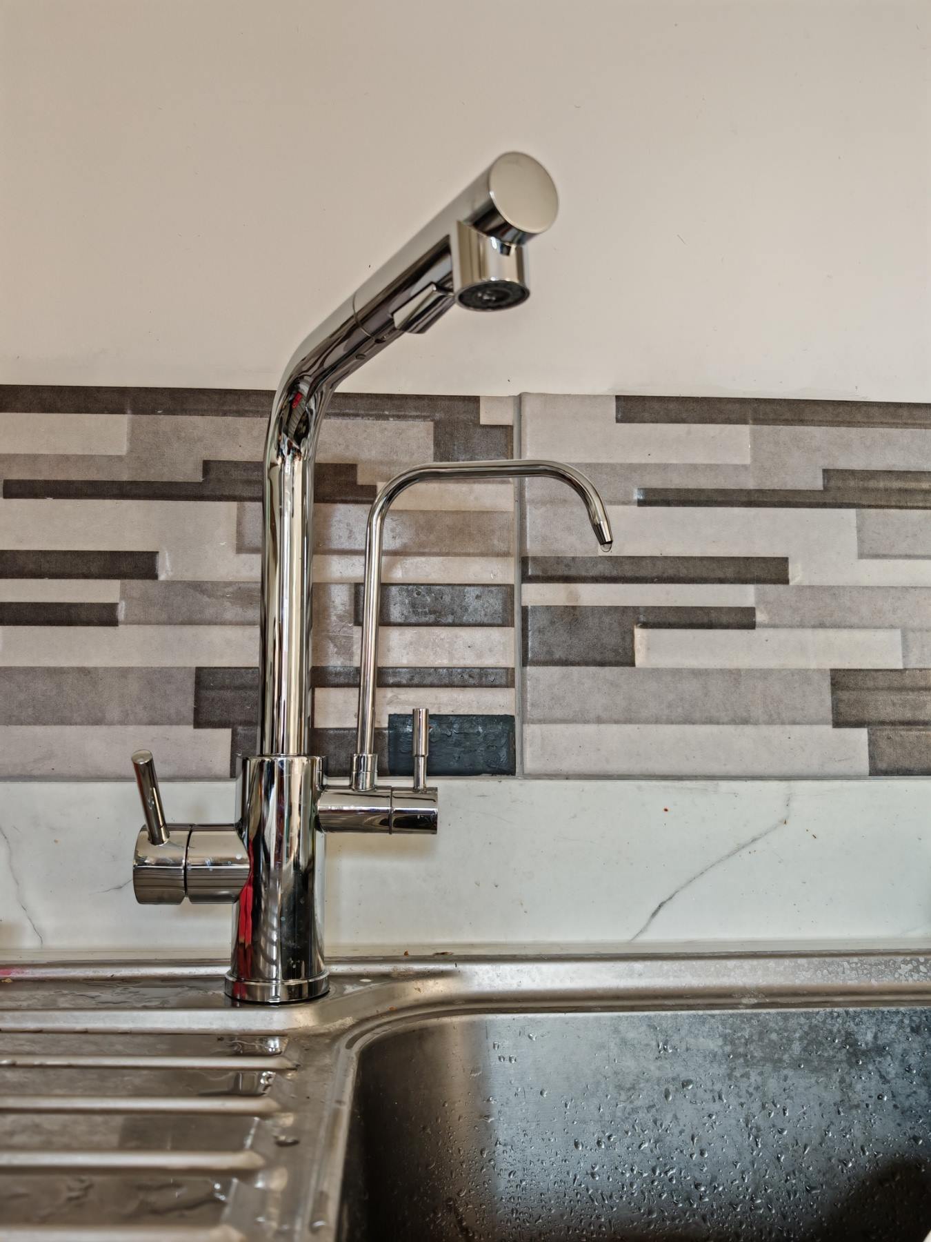A separate filtered drinking water tap fitted alongside a kitchen mixer tap