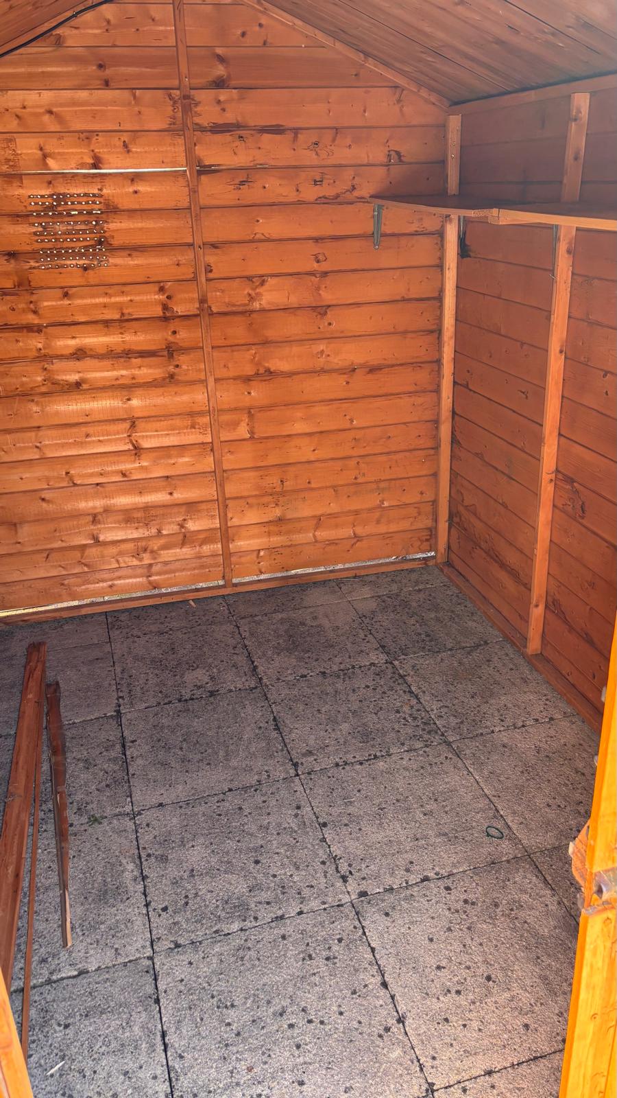 The shed with its old floor taken out, down to the paving slabs underneath