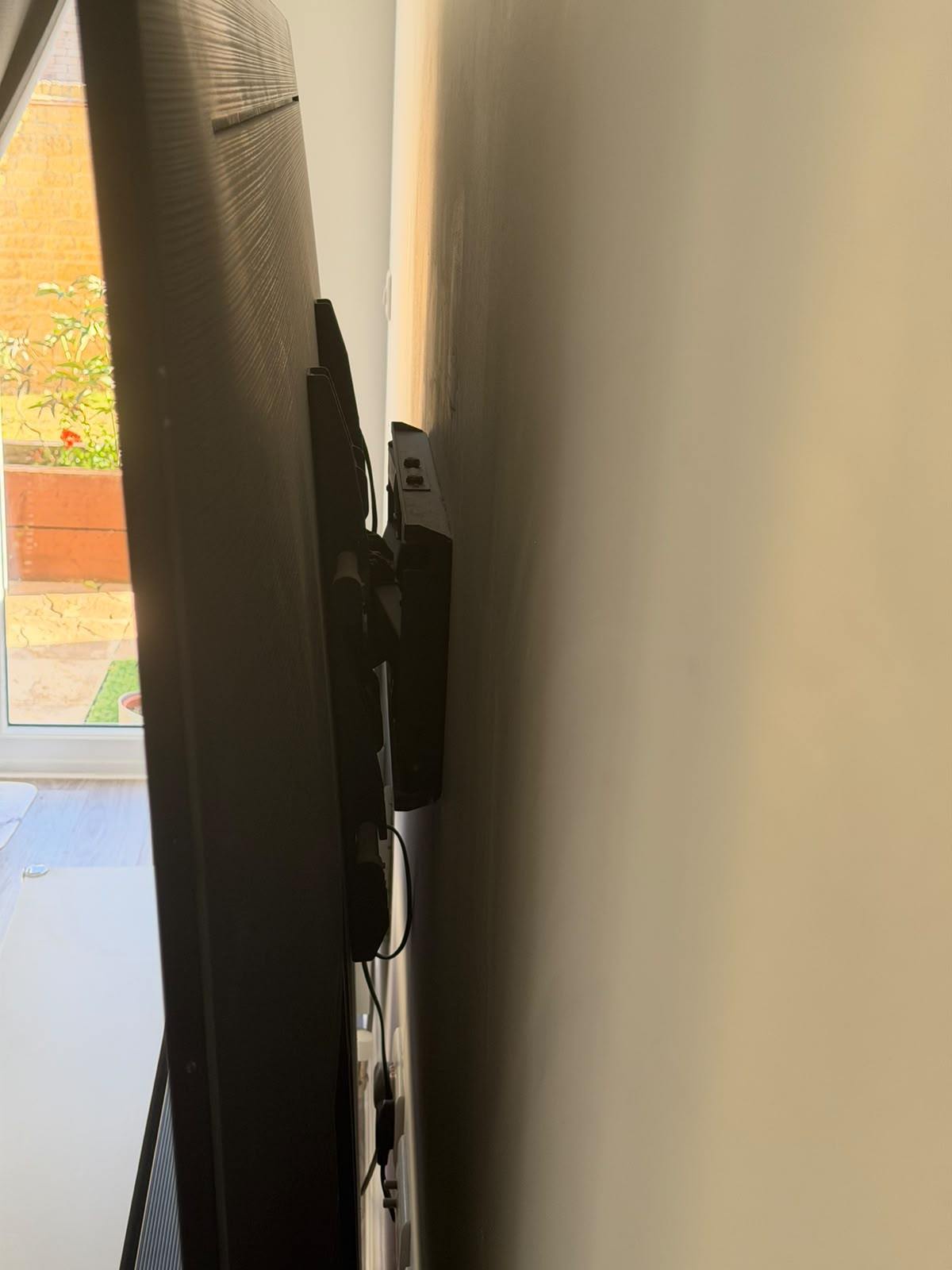 Side view showing how close the television sits to the wall when the bracket is folded flat
