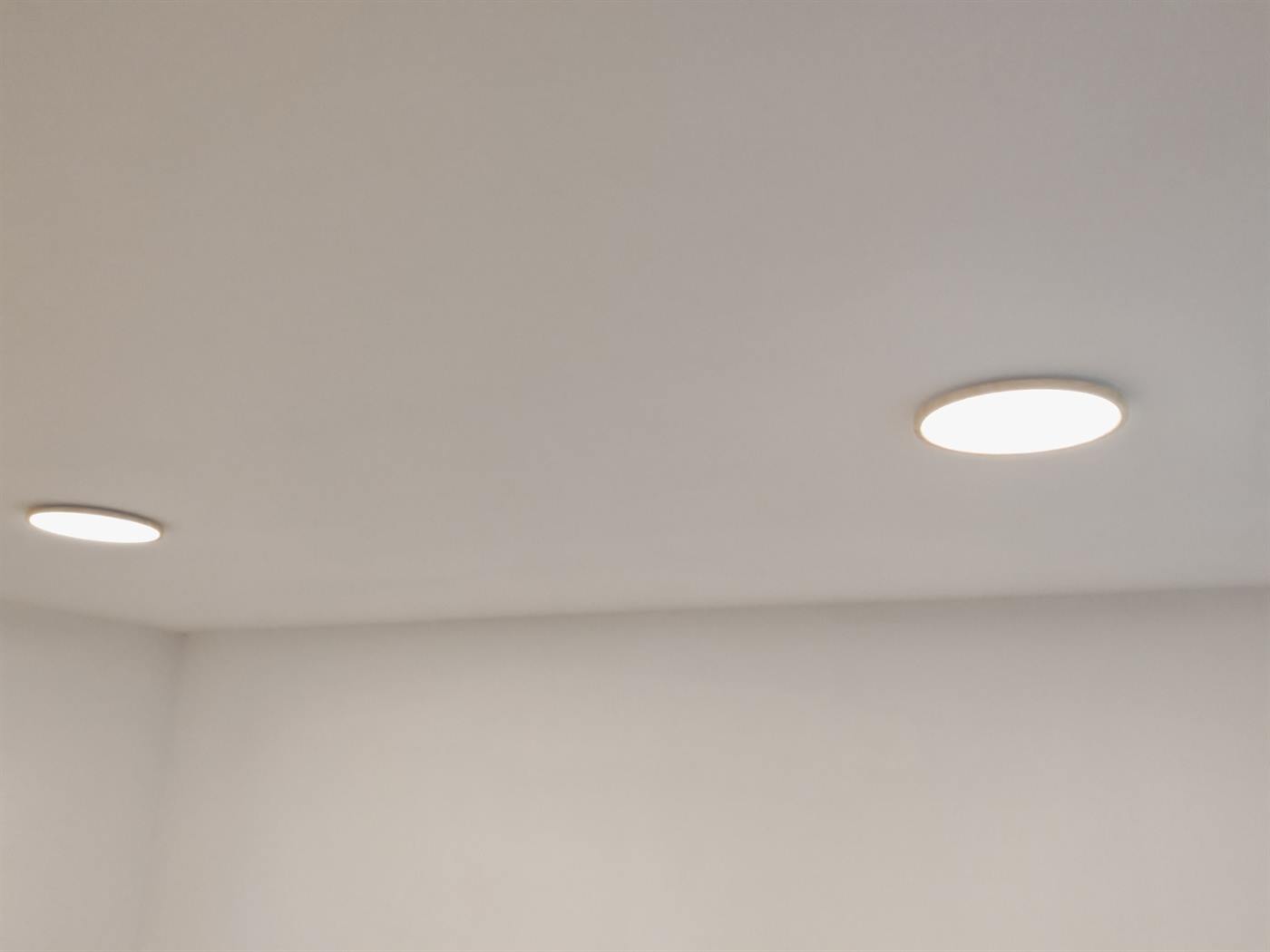 Two flush oak-rimmed LED ceiling lights fitted and switched on in a room in Oxfordshire
